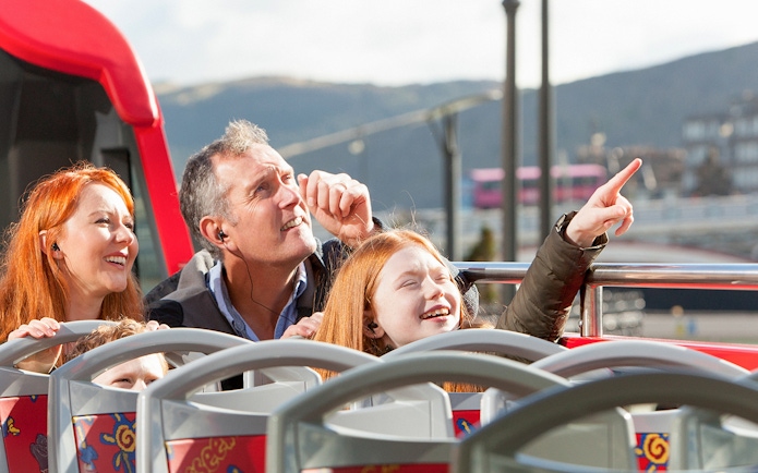 Family enjoying The Royal Edinburgh Tour on an open-top bus.