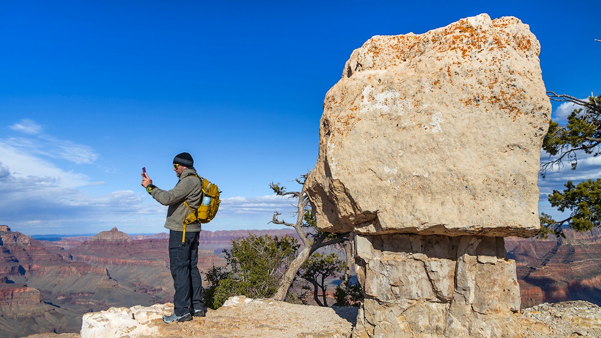 Hiker photographing view at Shoshone Point, Grand Canyon National Park, Arizona.