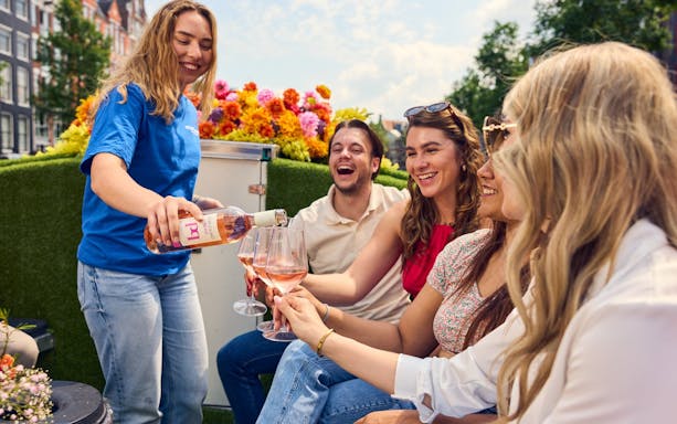 Guests enjoying wine on a luxury flower boat during a city highlights cruise.