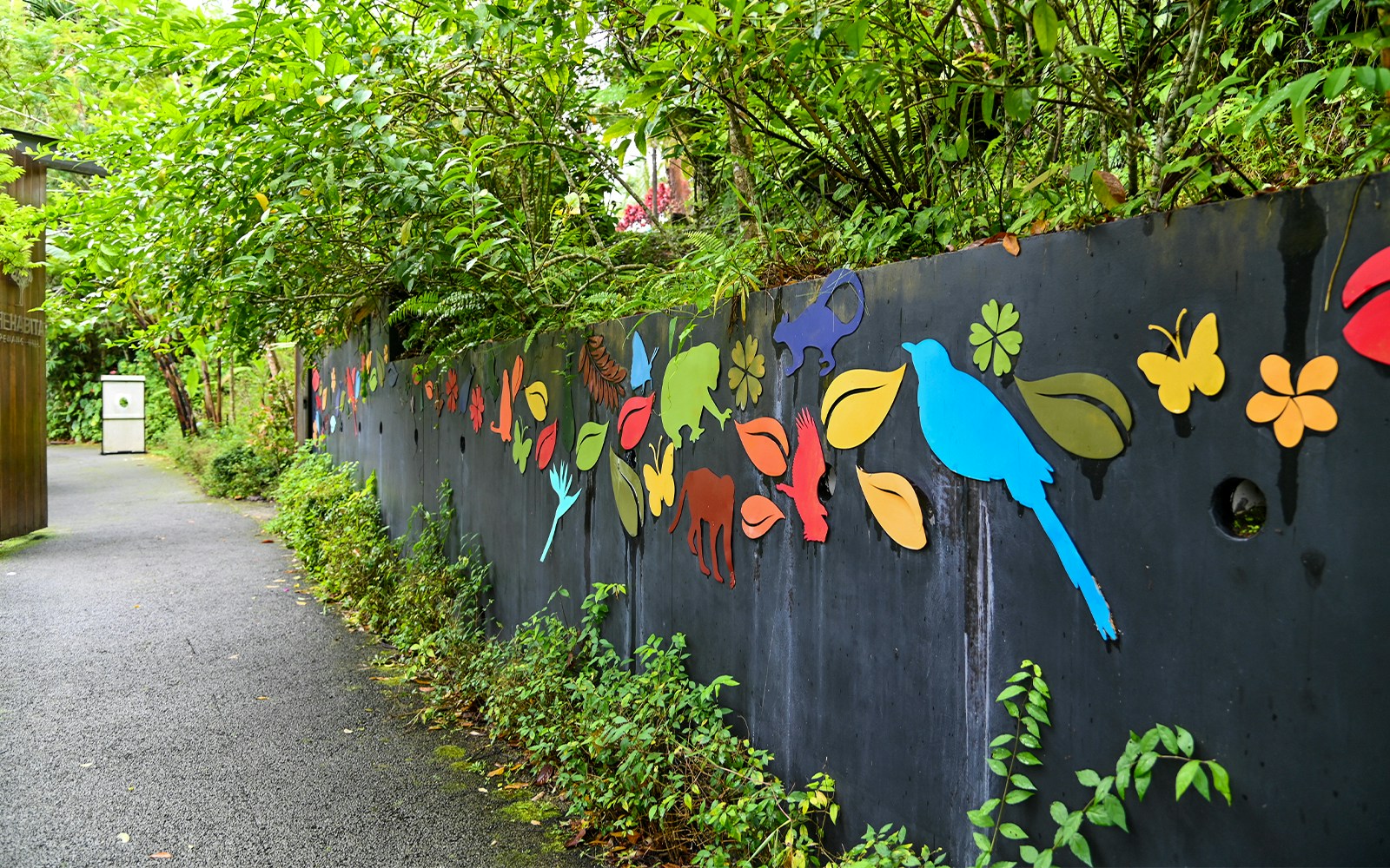 Breathtaking view of the lush greenery at Habitat Penang Hill, Malaysia, with tourists enjoying the scenic walkway