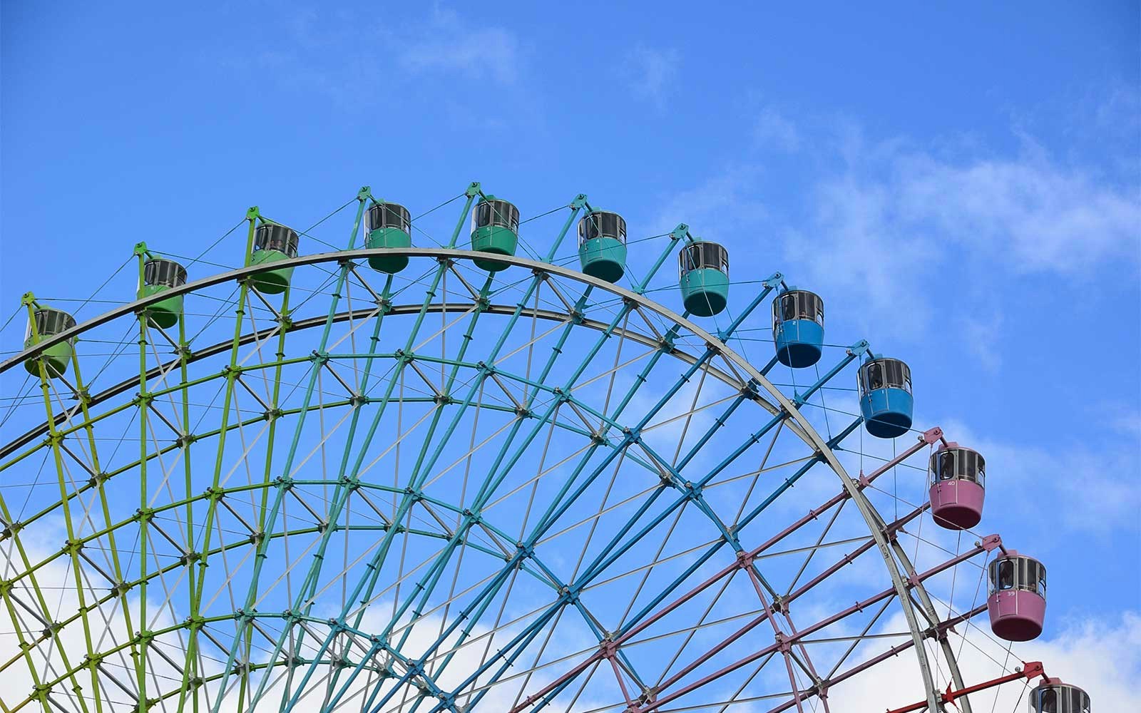 Ferris wheel at Hirakata Park against a blue sky.