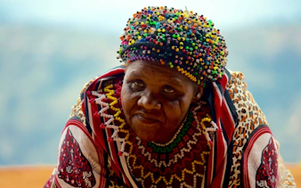 Zulu woman in traditional attire at PheZulu Cultural Village during Mandela Capture Site tour.