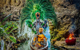 Performers in traditional Mayan attire on a canoe at Xcaret Park, Mexico.