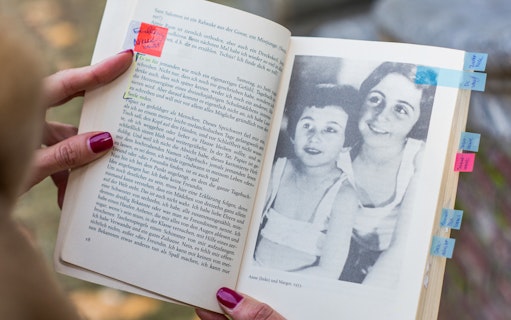 Open Anne Frank's diary with a photo of Anne and Margot, Amsterdam.