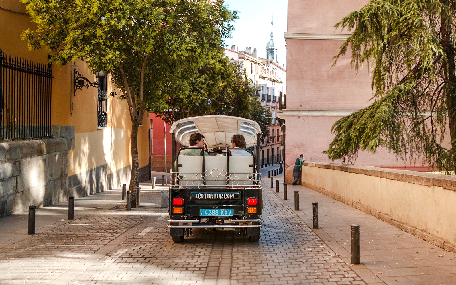 Electric tuk-tuk on a cobblestone street in Madrid, Spain.