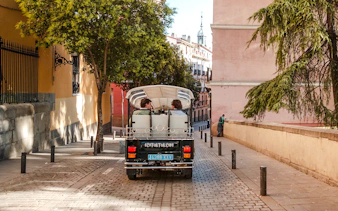 Electric tuk-tuk on a cobblestone street in Madrid, Spain.
