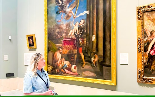 Visitor admiring a large Renaissance painting in a museum gallery.