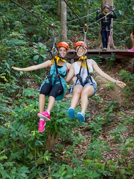 Visitors ziplining through the forest at Hanuman World, Thailand.