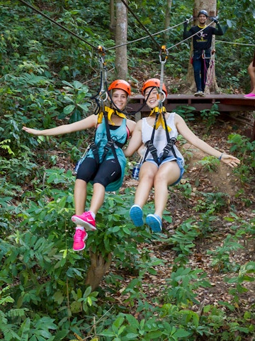 Visitors ziplining through the forest at Hanuman World, Thailand.