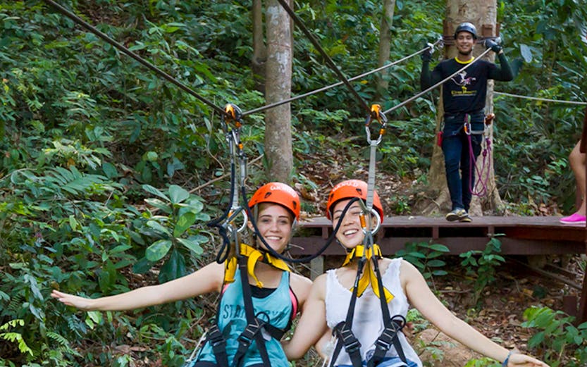 Visitors ziplining through the forest at Hanuman World, Thailand.
