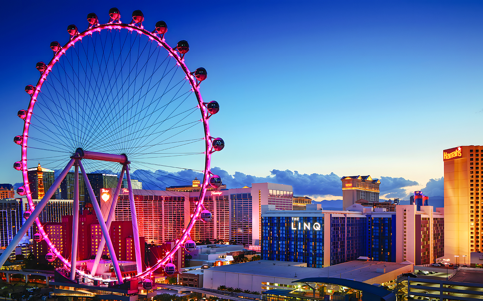 High Roller Wheel illuminated at dusk, Las Vegas skyline in background.