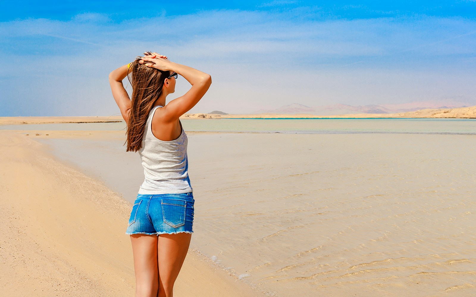 Woman standing on sandy beach at Ras Mohammed National Park, Egypt.