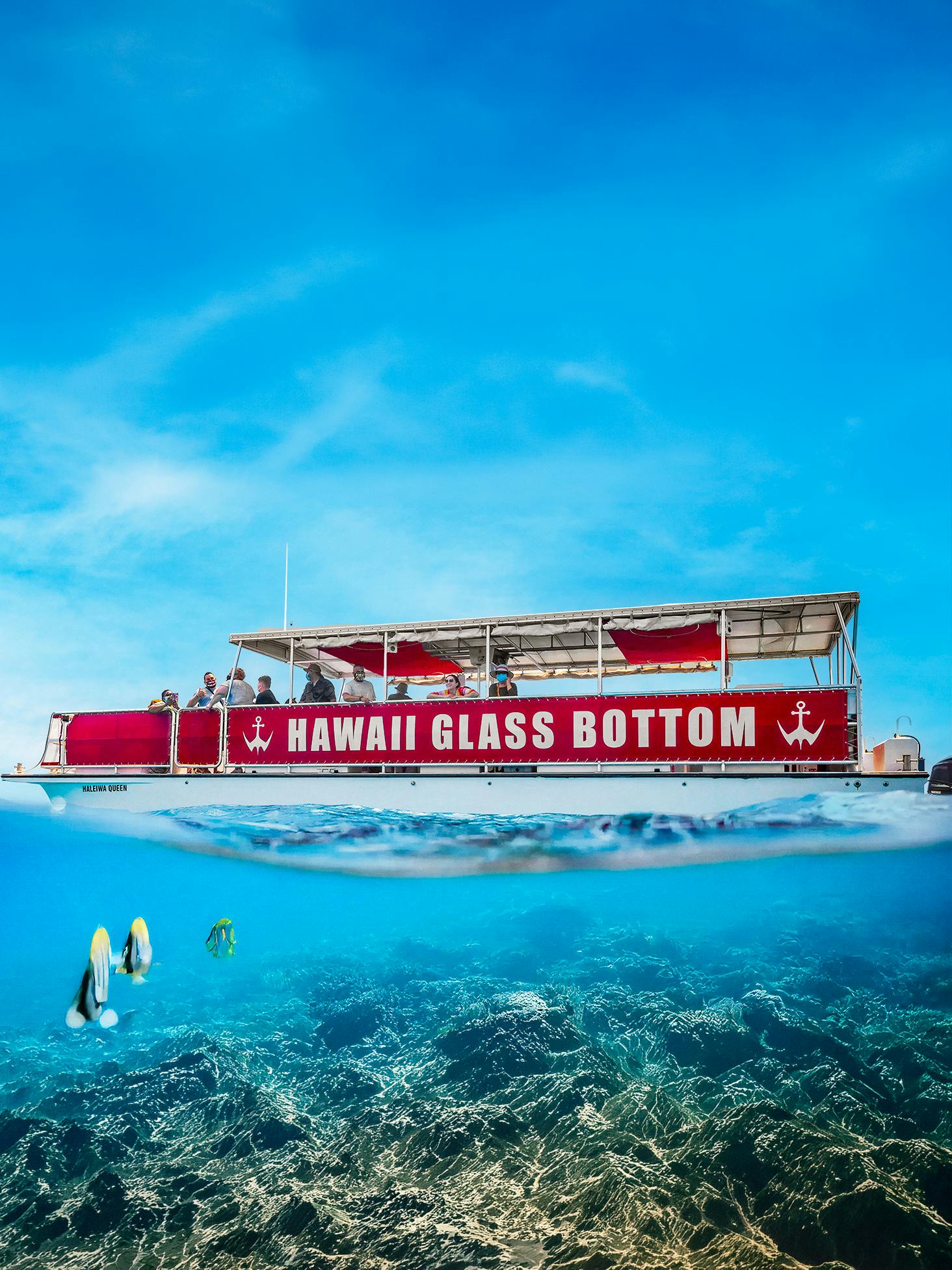 Hawaii Glass Bottom Boat with passengers sailing over coral reef.