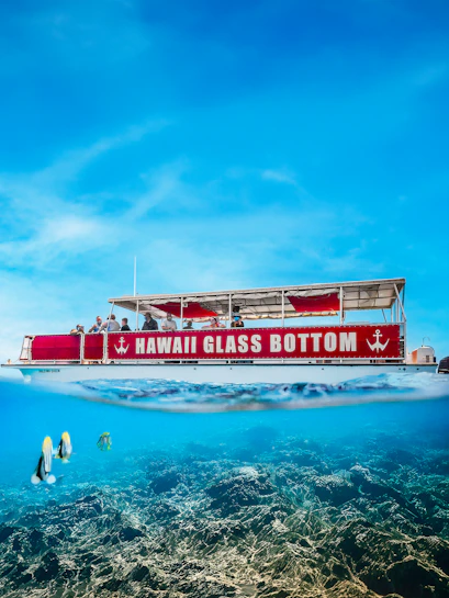 Hawaii Glass Bottom Boat with passengers sailing over coral reef.