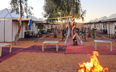 Desert camp with tents and fire pit on Merzouga Dunes during 3-day camel trek.