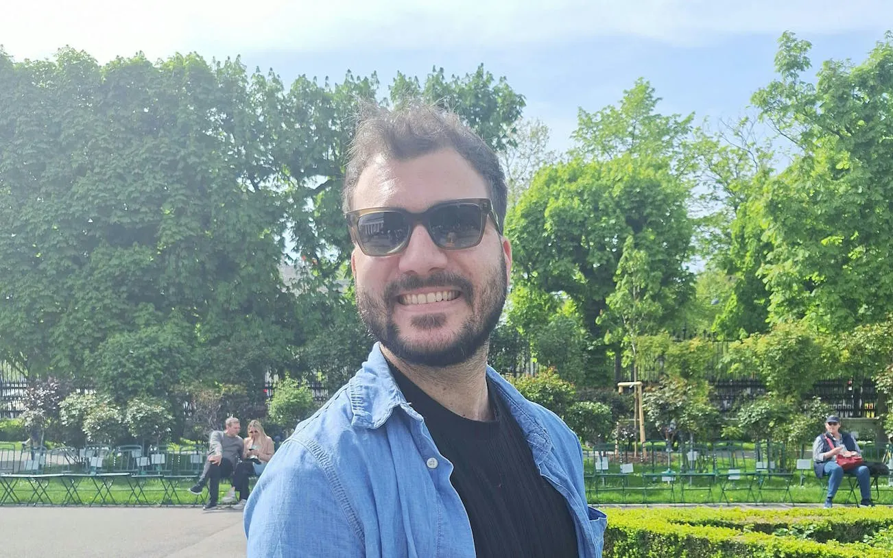 Man smiling in a Vienna park, part of a self-guided city exploration game.