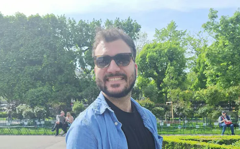 Man smiling in a Vienna park, part of a self-guided city exploration game.
