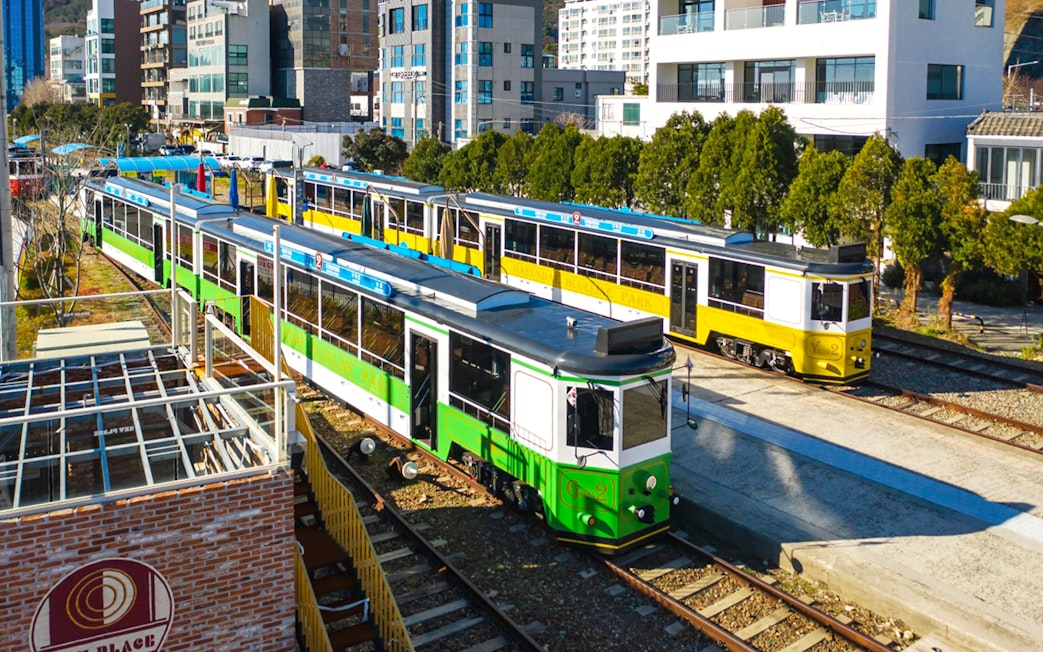 Blueline Park Sky Capsule trains in Busan cityscape during one-day city tour.