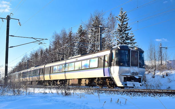 Train traveling through snowy landscape in Sapporo, Japan, part of 4-Day Sapporo-Noboribetsu Area Pass.