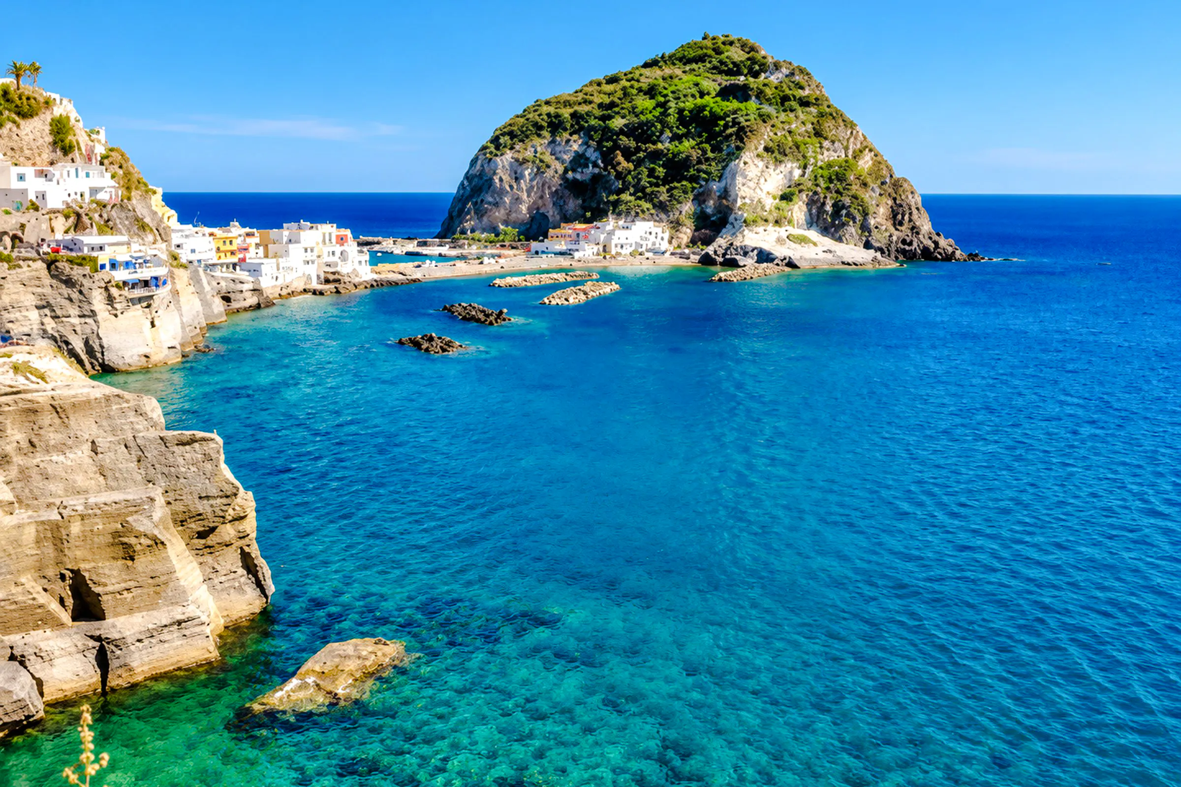 Ischia coastline with clear blue water and rocky cliffs, Naples boat tour location.