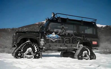 Snow vehicle with tracks on a snowy landscape in Ushuaia for full day snow experience.