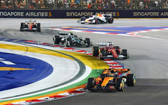 Cars racing around a turn at the Formula 1 Singapore Grand Prix.