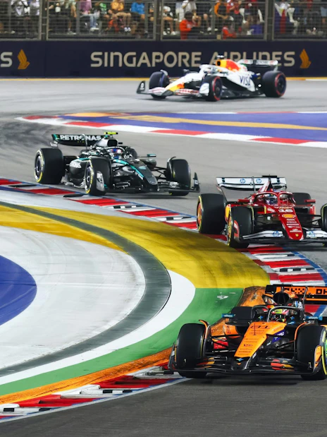 Cars racing around a turn at the Formula 1 Singapore Grand Prix.