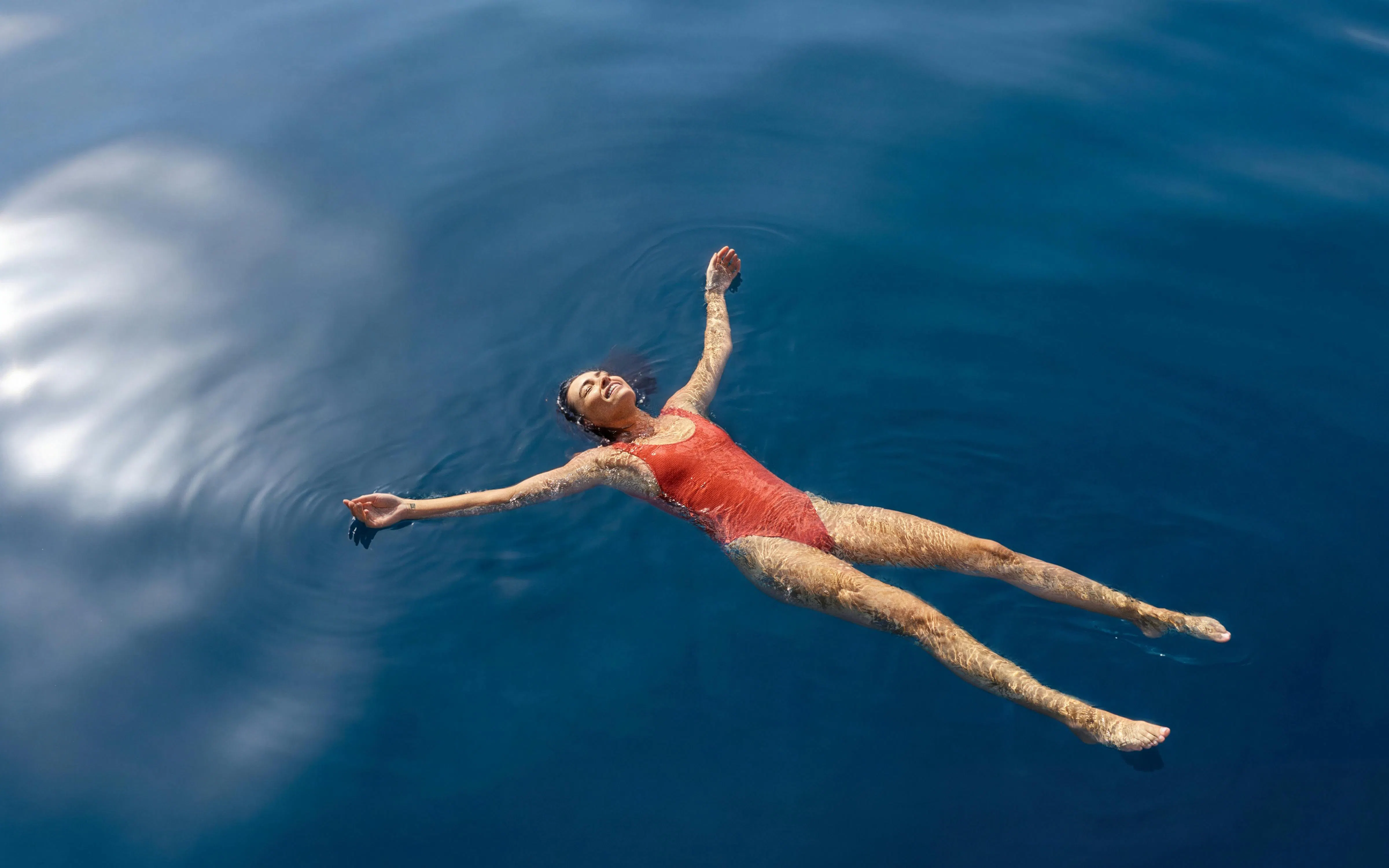 Person floating in clear blue water during Whitehaven Beach tour, Whitsundays.