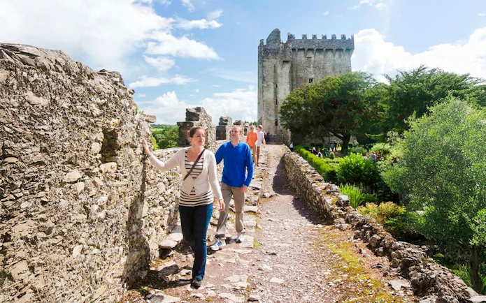Tourists walking along the stone path at Blarney Castle, Ireland.