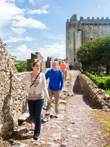 Tourists walking along the stone path at Blarney Castle, Ireland.