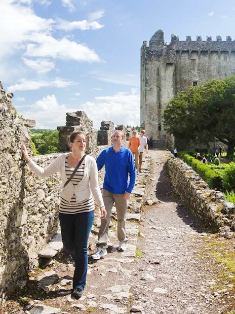 Tourists walking along the stone path at Blarney Castle, Ireland.