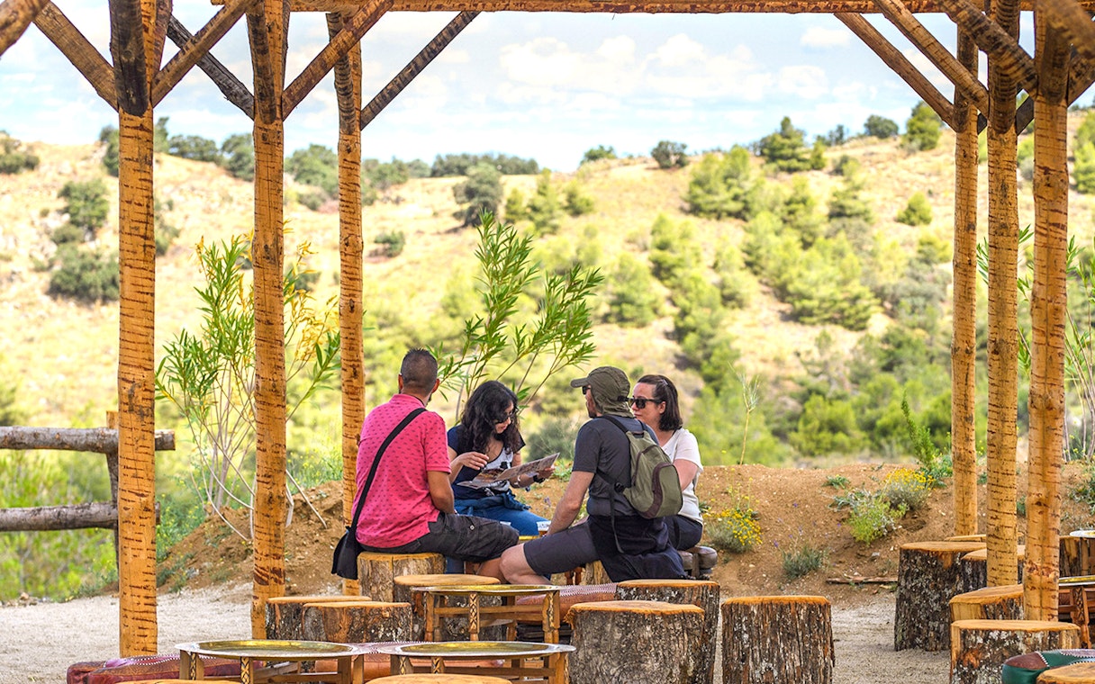 Visitors relaxing under a wooden shelter at Puy du Fou Park.