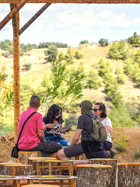 Visitors relaxing under a wooden shelter at Puy du Fou Park.