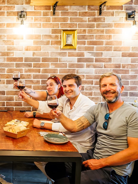 Tourists with guide enjoying drinks and food at a restaurant during Lisbon Food Walk in Baixa.