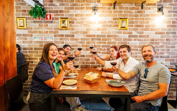 Tourists with guide enjoying drinks and food at a restaurant during Lisbon Food Walk in Baixa.