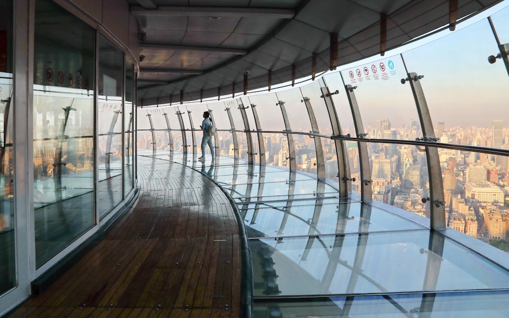 Observation deck view at Oriental Pearl Tower, Shanghai, with city skyline in the background.