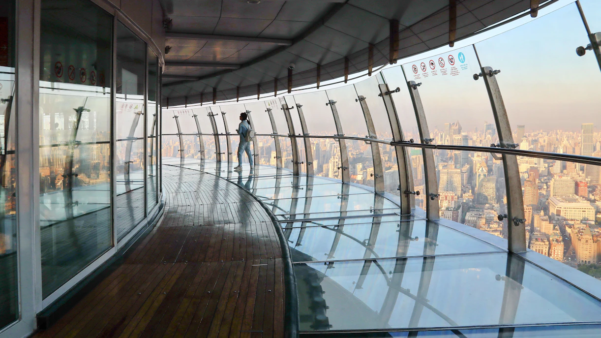 Observation deck view at Oriental Pearl Tower, Shanghai, with city skyline in the background.