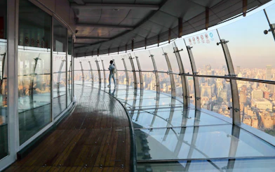 Observation deck view at Oriental Pearl Tower, Shanghai, with city skyline in the background.
