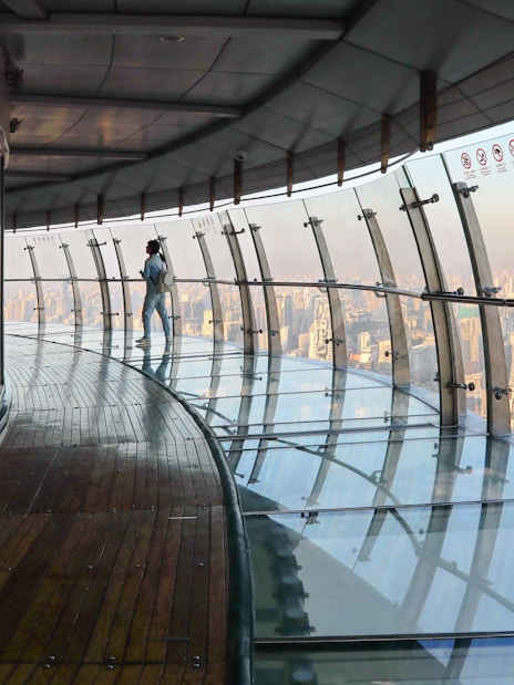 Observation deck view at Oriental Pearl Tower, Shanghai, with city skyline in the background.