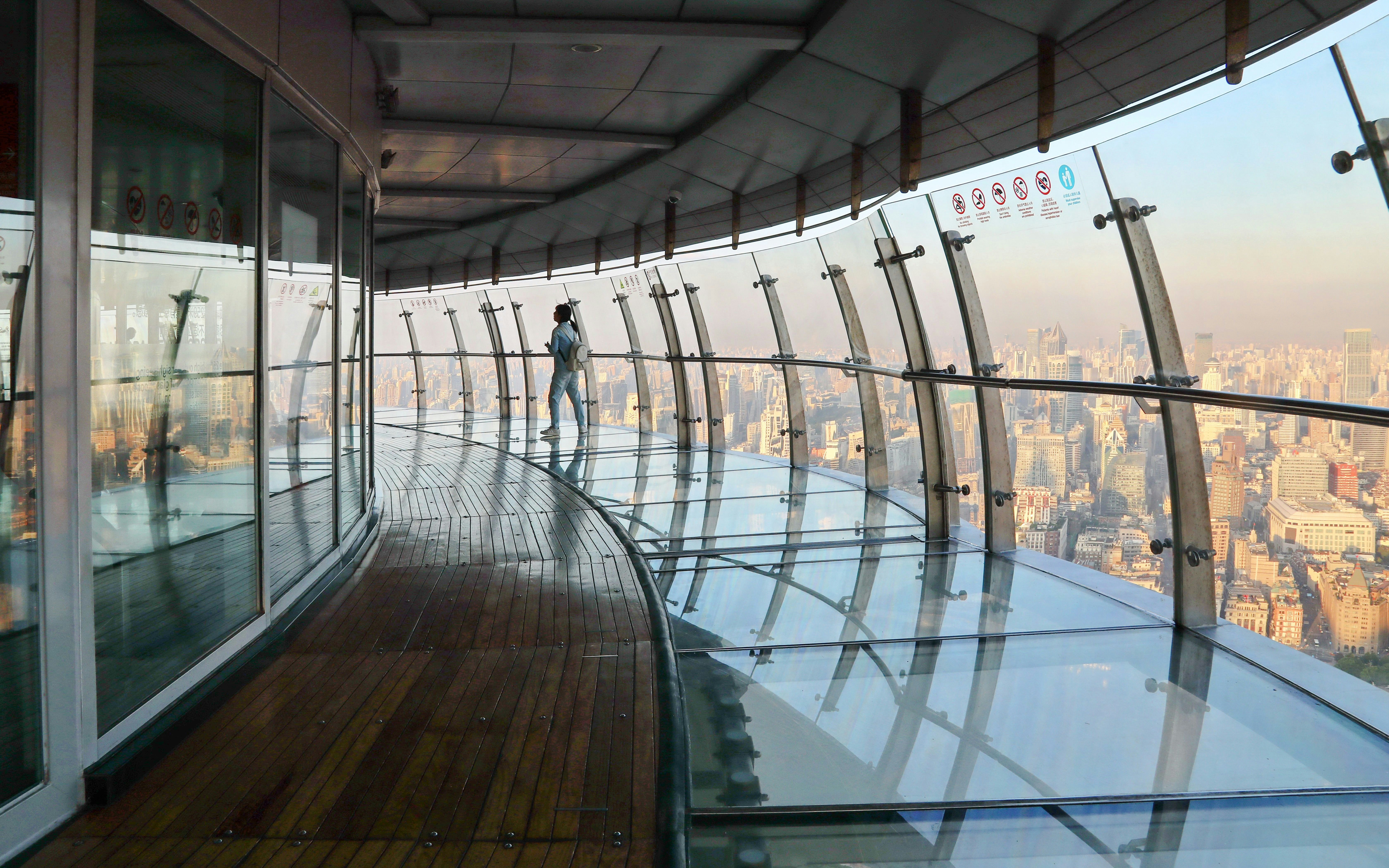 Observation deck view at Oriental Pearl Tower, Shanghai, with city skyline in the background.