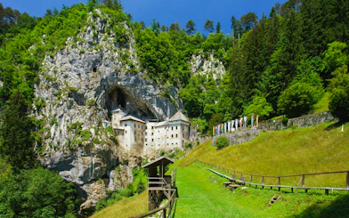 Predjama Castle nestled in a cliffside surrounded by lush greenery, Slovenia.