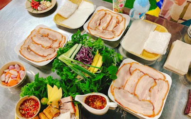 Local dishes with fresh herbs and sliced pork on Da Nang food tour.