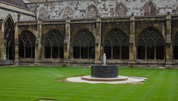 Westminster Abbey garden with fountain and Gothic arches in London.