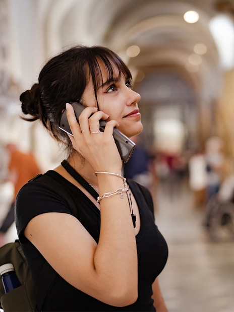 Visitor using an audio guide inside a historic building, related to Westminster Abbey and Tower of London tour.