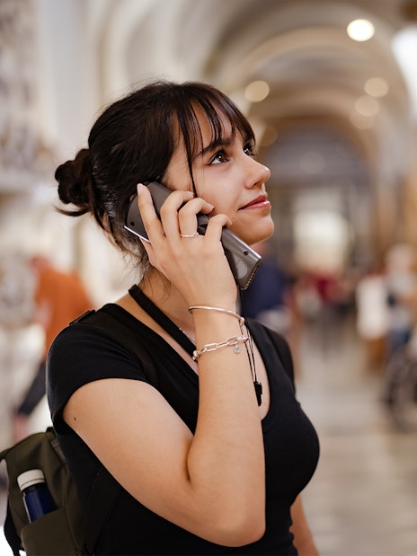 Visitor using an audio guide inside a historic building, related to Westminster Abbey and Tower of London tour.