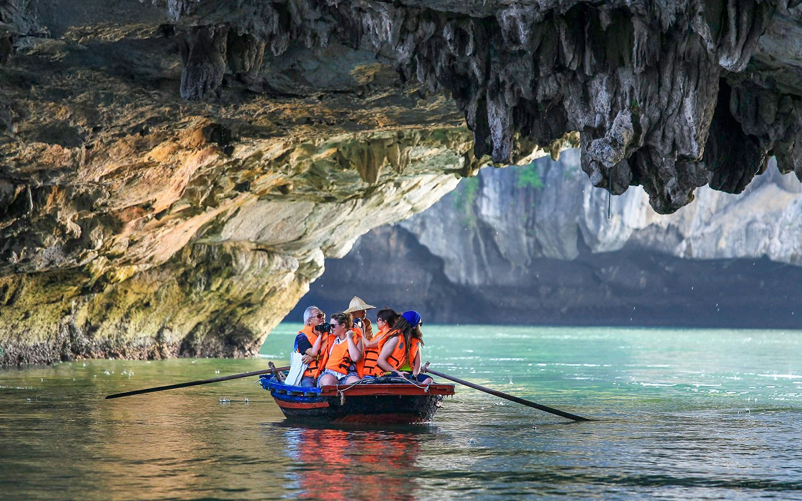 Ha Long Bay cruise ship sailing past limestone karsts and emerald waters.
