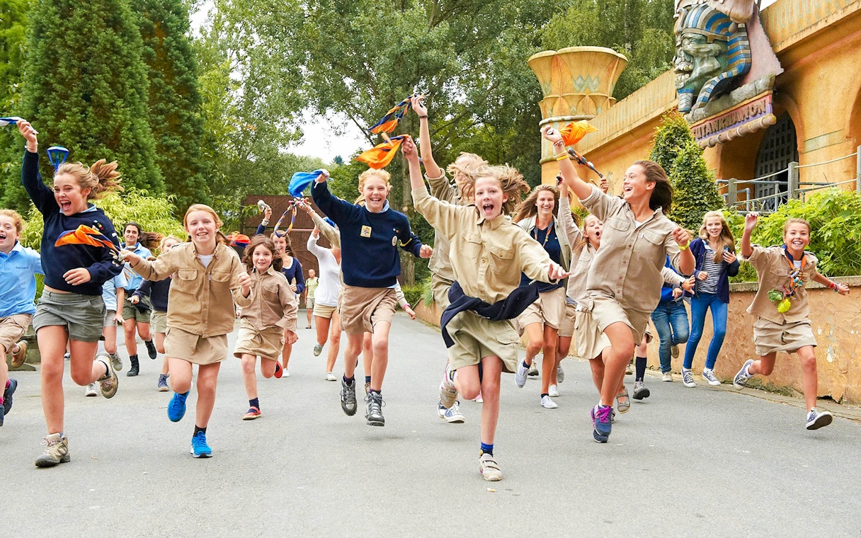 Children running and playing at an amusement park with themed decorations.