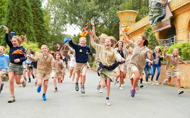 Children running and playing at an amusement park with themed decorations.