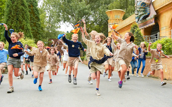 Children running and playing at an amusement park with themed decorations.