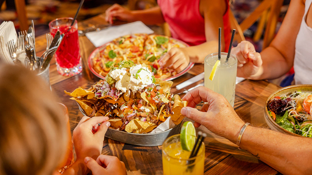 Dining at Jane's Rivertown Restaurant, Dreamworld, Gold Coast with nachos and drinks on the table.